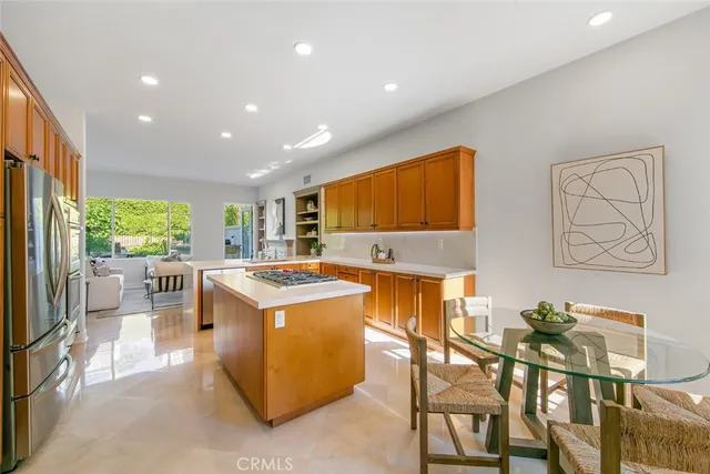 a view of a kitchen with kitchen island a stove a refrigerator a dining table and chairs with outer view