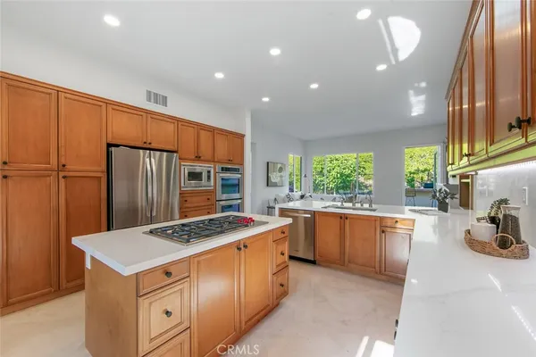 a kitchen that has a lot of cabinets in it and stainless steel appliances