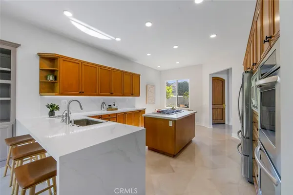 a large kitchen with stainless steel appliances granite countertop a sink and a refrigerator
