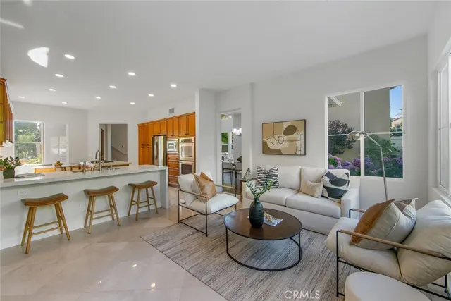 a living room with furniture wooden floor and a large window