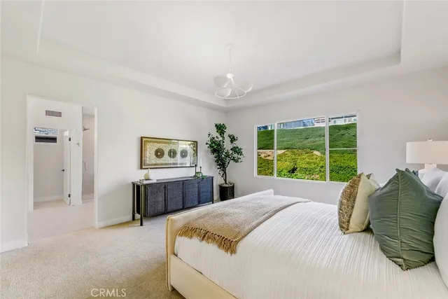 a bedroom with a large bed and a chandelier