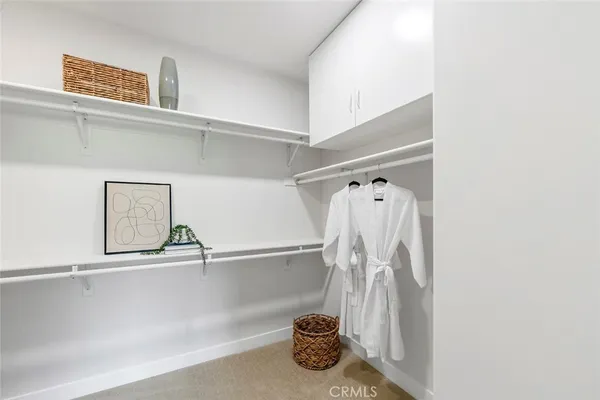 a view of walk in closet with clothes and shoes