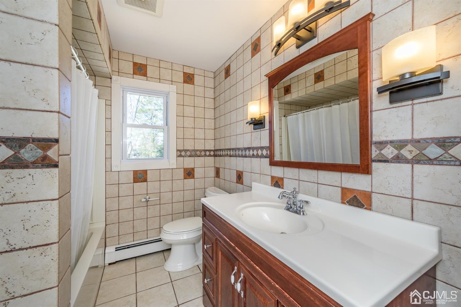 627 Lloyd Road Aberdeen, NJ 07747 - Photo 13 of 32 a bathroom with a sink a toilet and shower