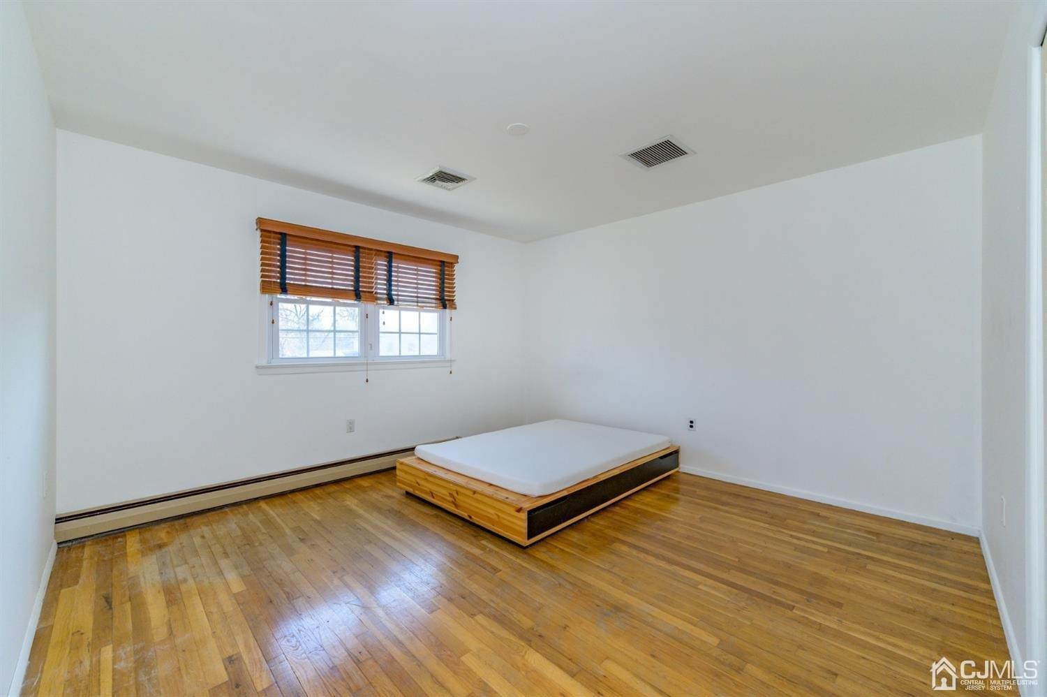 627 Lloyd Road Aberdeen, NJ 07747 - Photo 14 of 32 a view of empty room with wooden floor and fan