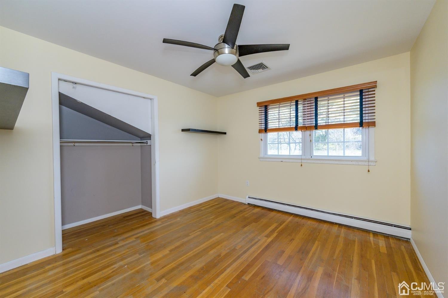 627 Lloyd Road Aberdeen, NJ 07747 - Photo 16 of 32 a view of empty room with wooden floor and fan