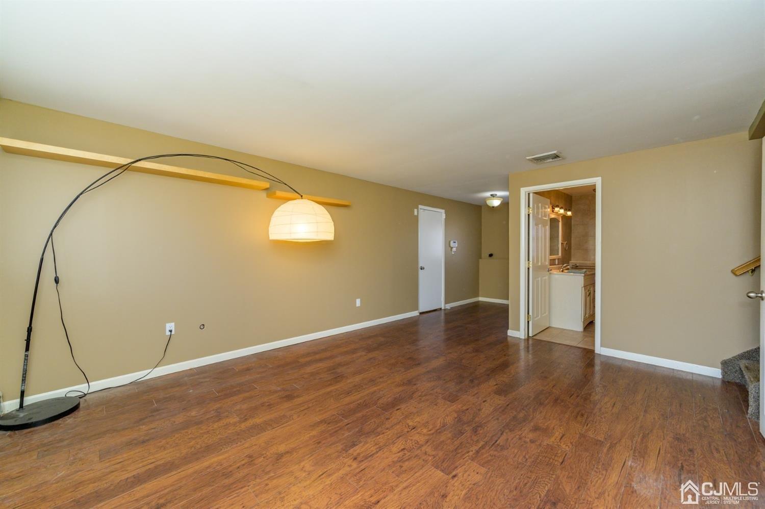 627 Lloyd Road Aberdeen, NJ 07747 - Photo 20 of 32 an empty room with wooden floor and windows