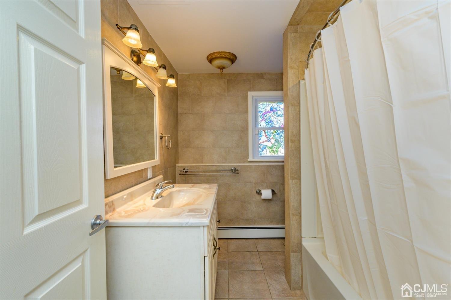 627 Lloyd Road Aberdeen, NJ 07747 - Photo 21 of 32 a bathroom with a granite countertop sink and a mirror