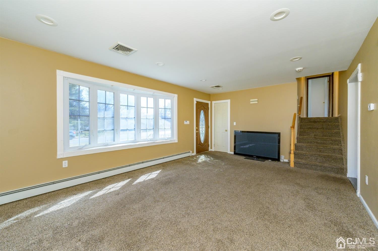 627 Lloyd Road Aberdeen, NJ 07747 - Photo 4 of 32 a view of an empty room with a fireplace and a window