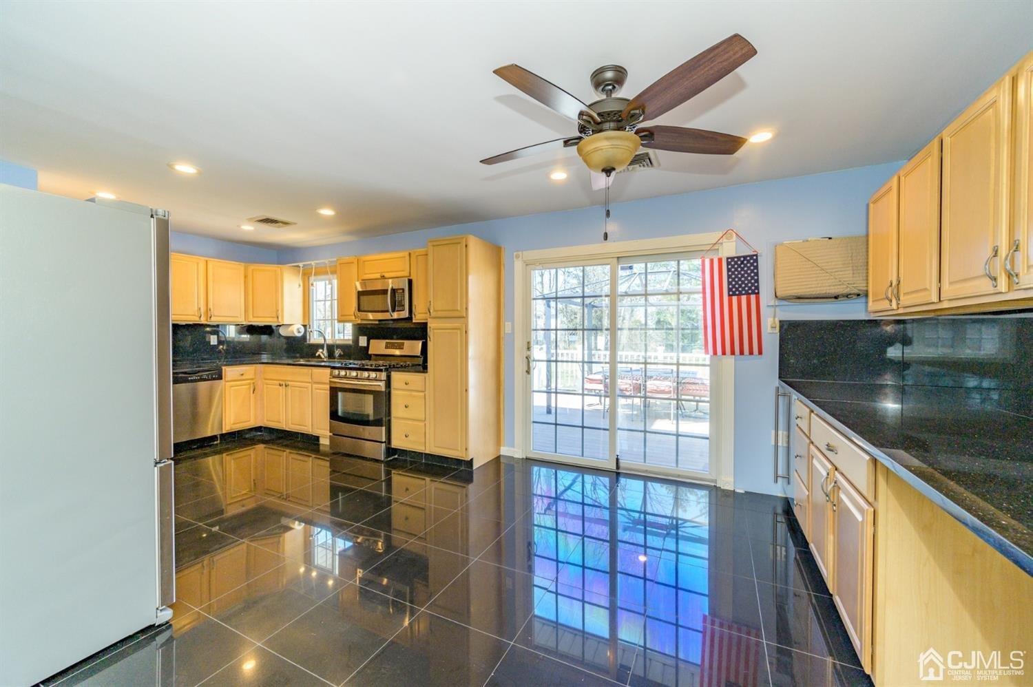 627 Lloyd Road Aberdeen, NJ 07747 - Photo 6 of 32 a view of a kitchen with kitchen island granite countertop a refrigerator cabinets dining table and chairs