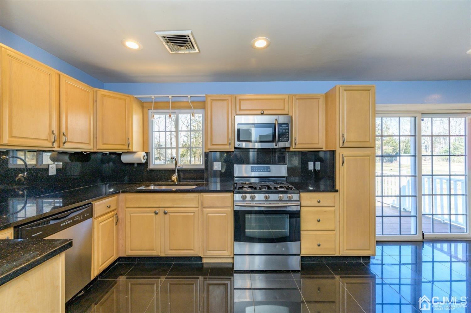 627 Lloyd Road Aberdeen, NJ 07747 - Photo 8 of 32 a kitchen with stainless steel appliances a stove sink and microwave