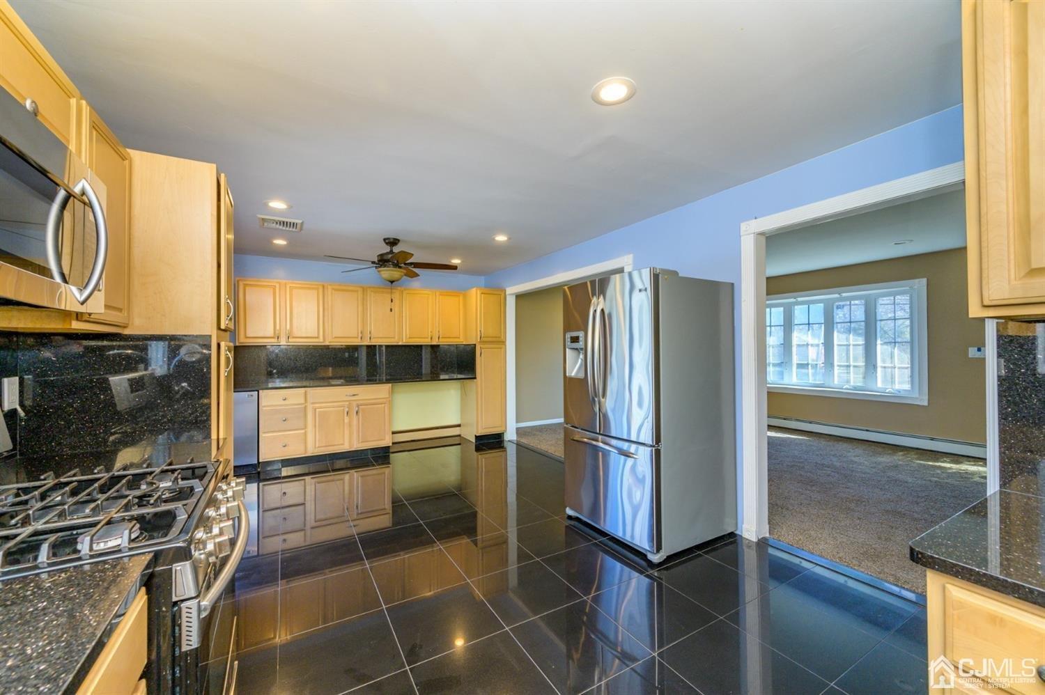 627 Lloyd Road Aberdeen, NJ 07747 - Photo 9 of 32 a kitchen with stainless steel appliances granite countertop a refrigerator and a stove top oven