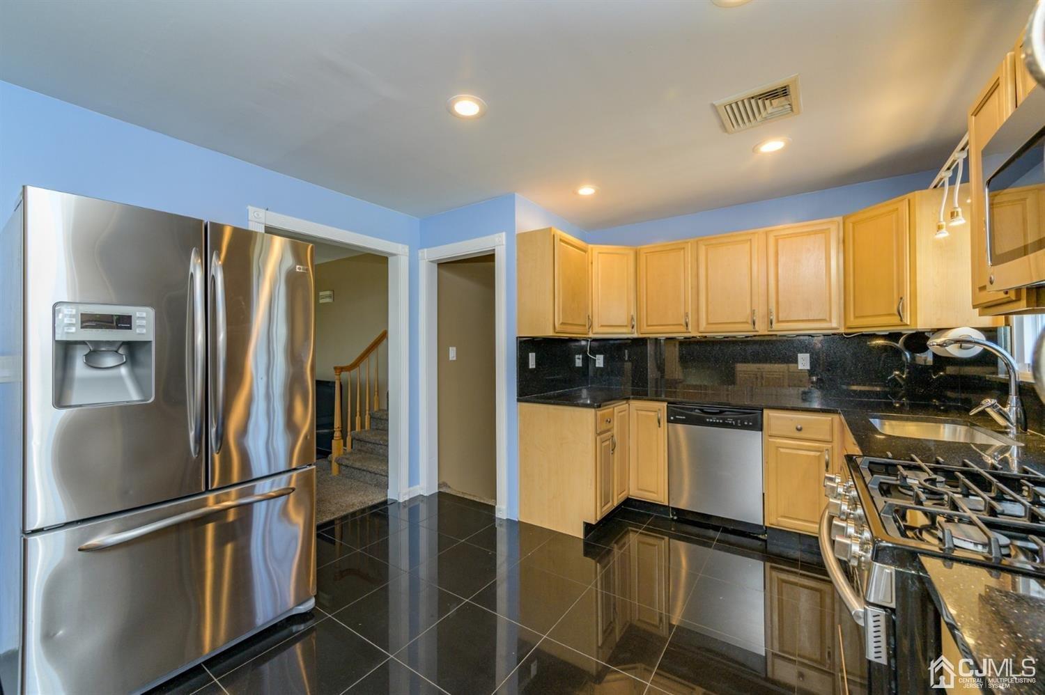 627 Lloyd Road Aberdeen, NJ 07747 - Photo 10 of 32 a kitchen with granite countertop stainless steel appliances a refrigerator and cabinets