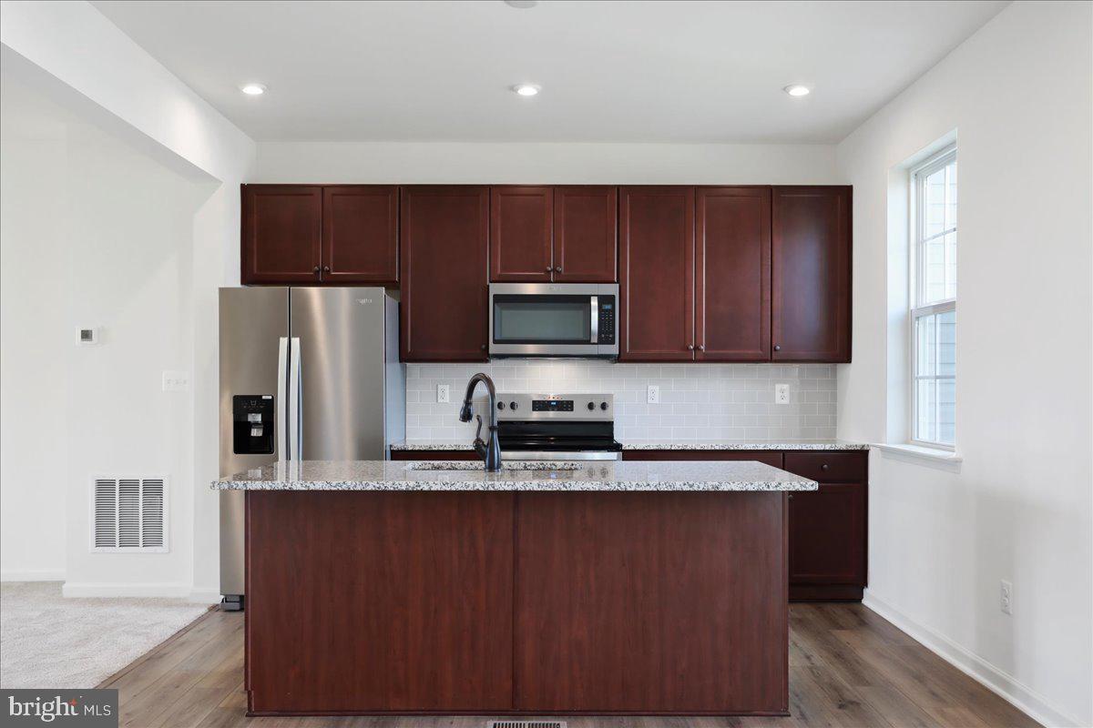71 Stafford Place Falling Waters, WV 25419 - Photo 11 of 48 a kitchen with stainless steel appliances granite countertop a refrigerator microwave and sink
