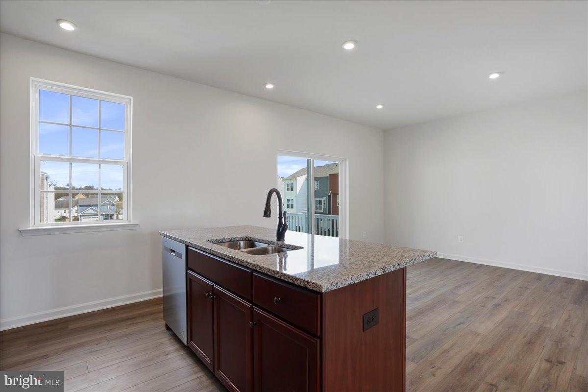 71 Stafford Place Falling Waters, WV 25419 - Photo 6 of 48 a room with kitchen island a sink wooden floor and glass door