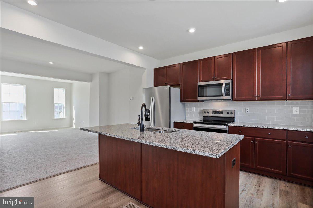 71 Stafford Place Falling Waters, WV 25419 - Photo 7 of 48 a kitchen with stainless steel appliances granite countertop a sink stove microwave and refrigerator