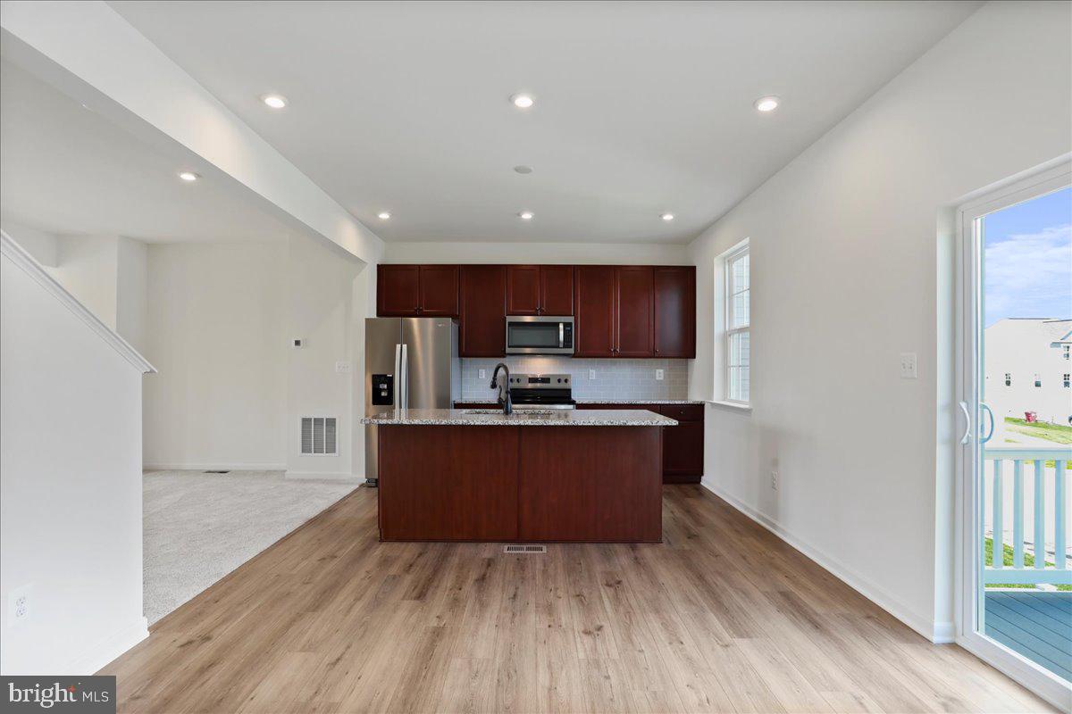 71 Stafford Place Falling Waters, WV 25419 - Photo 9 of 48 a large kitchen with stainless steel appliances granite countertop a large counter top a wooden floors and a large window