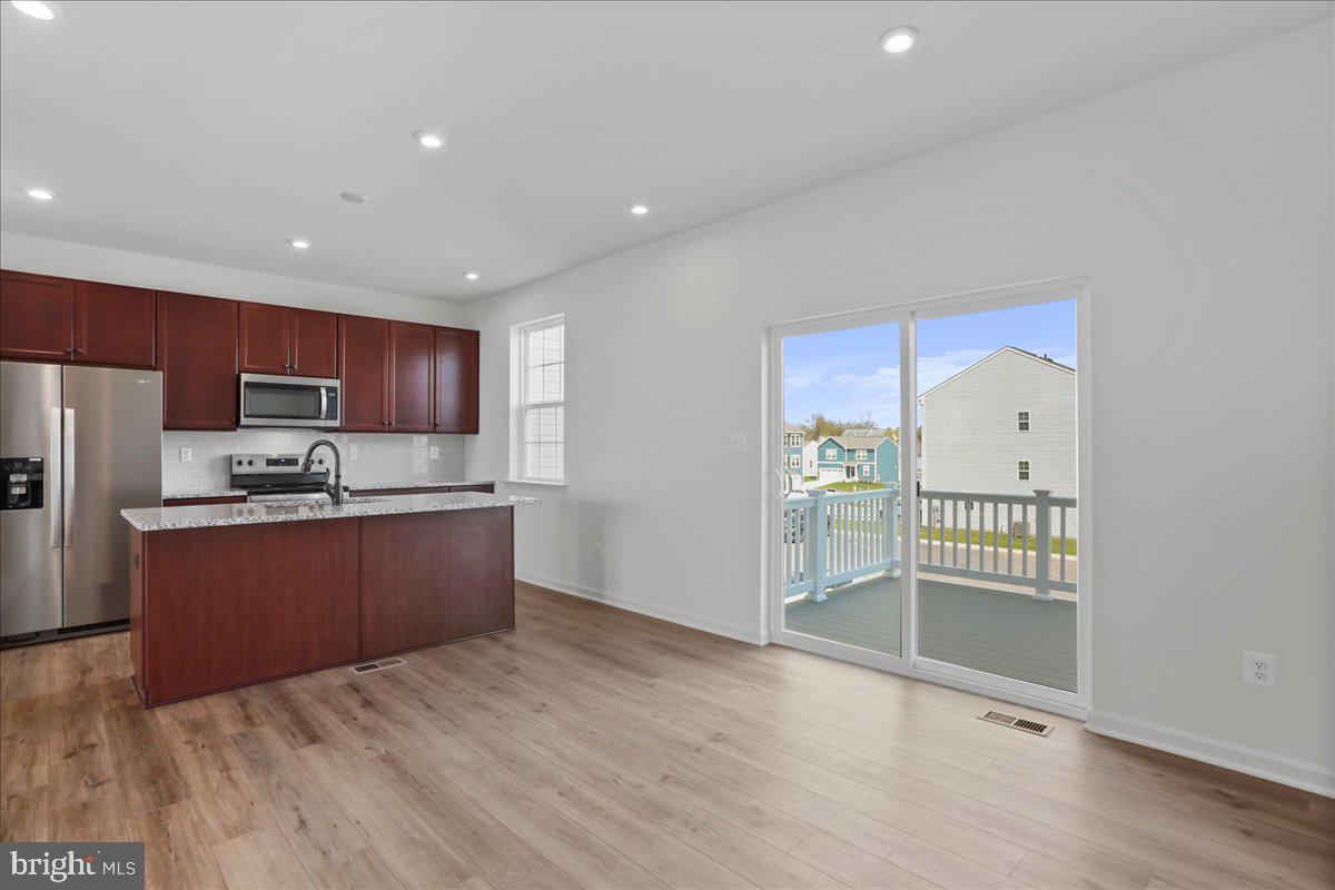 71 Stafford Place Falling Waters, WV 25419 - Photo 10 of 48 a large kitchen with stainless steel appliances kitchen island granite countertop a refrigerator and a sink