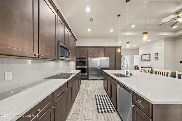 a kitchen with counter top space a sink stainless steel appliances and cabinets