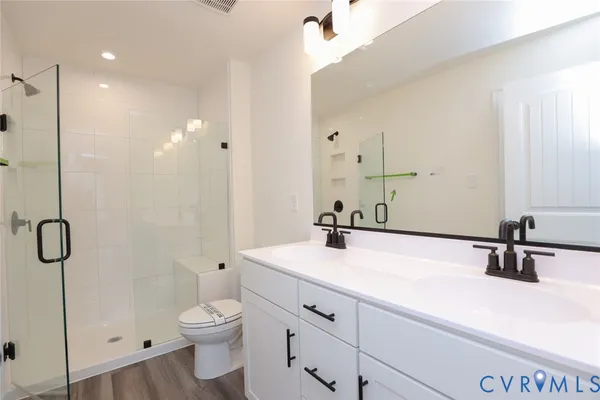 a bathroom with a sink a toilet and shower