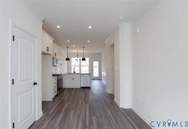 a kitchen with stainless steel appliances a refrigerator a sink dishwasher and a stove with wooden floor