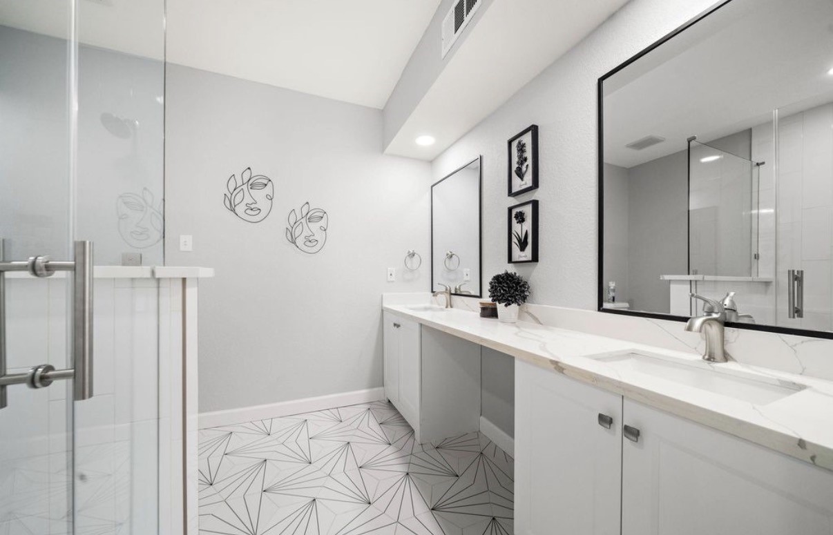 1633 Castle Court Houston, TX 77006 - Photo 10 of 38 Staged, beautifully updated bathroom featuring a spacious dual-sink vanity, modern fixtures, and a sleek glass-enclosed shower. Bright, airy finishes and clean lines create a spa-like atmosphere perfect for everyday comfort.
