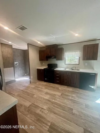 a large kitchen with kitchen island granite countertop a sink and cabinets