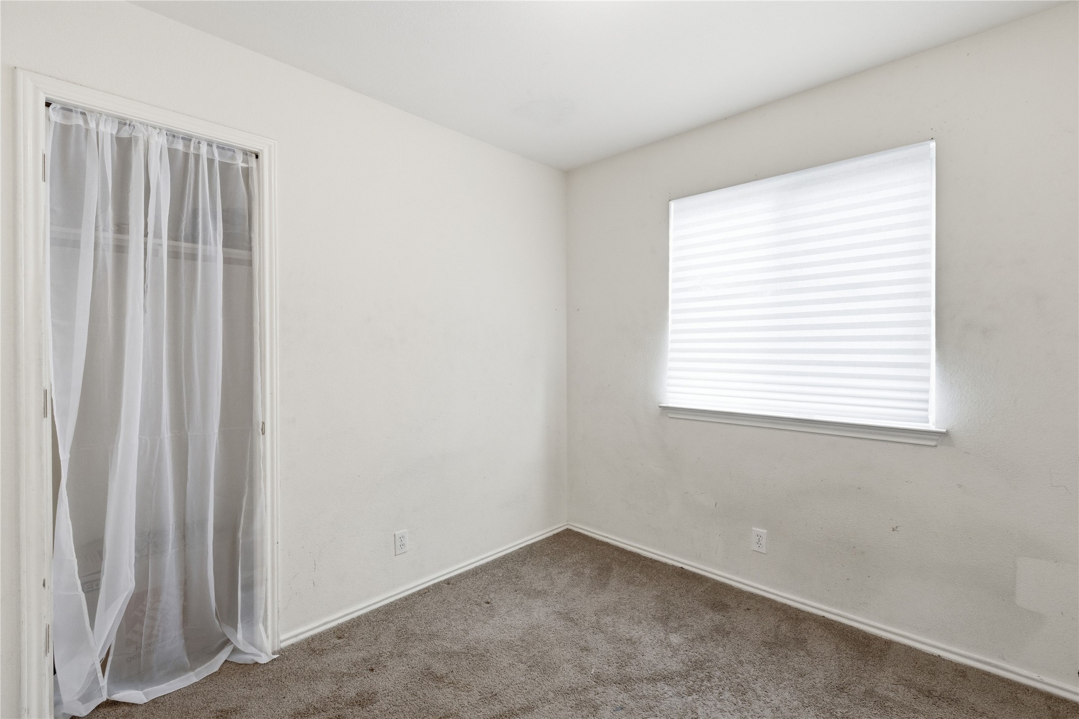 16112 Hamilton Point Circle Manor, TX 78653 - Photo 11 of 27 Interior room featuring light-toned walls, a single window with privacy blinds, and wall-to-wall carpeting