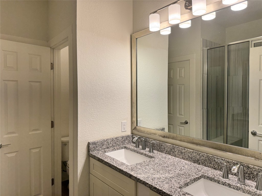 11415 Culzean Castle Drive Austin, TX 78717 - Photo 11 of 21 a bathroom with a granite countertop sink and a mirror