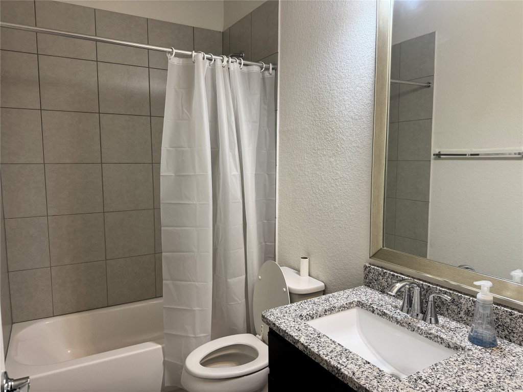 11415 Culzean Castle Drive Austin, TX 78717 - Photo 18 of 21 a bathroom with a granite countertop sink and a mirror