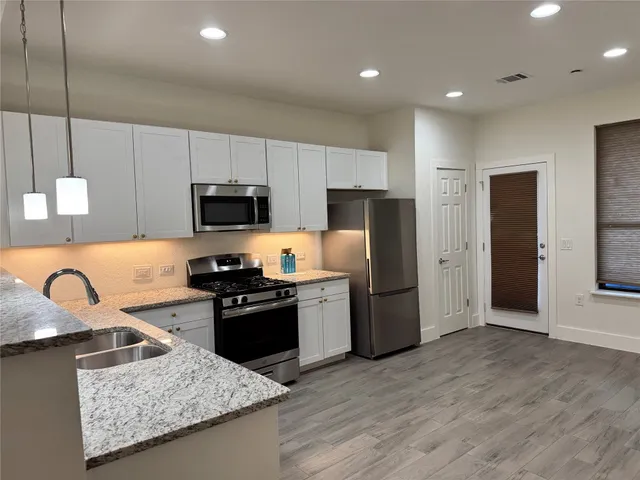 a view of a hallway with entryway wooden floor and front door