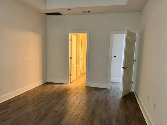 an empty room with wooden floor and window