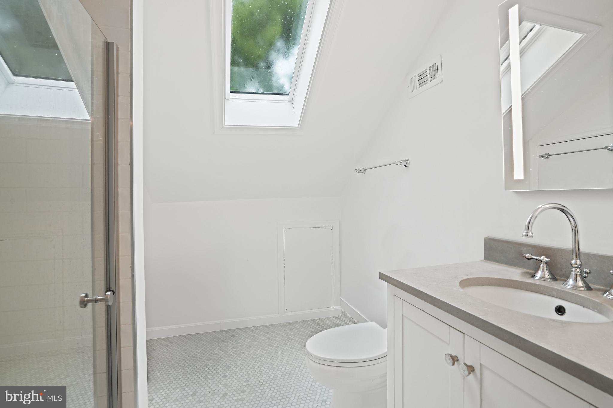 4621 Drummond Avenue Chevy Chase, MD 20815 - Photo 27 of 33 a bathroom with a granite countertop sink toilet and a mirror