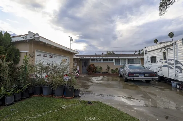 a front view of a house with a garden and plants