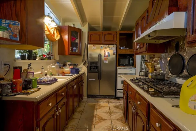a kitchen with stainless steel appliances granite countertop a stove a sink and a refrigerator