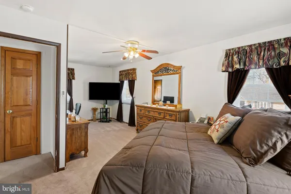 a bedroom with a bed flat screen tv and a couch