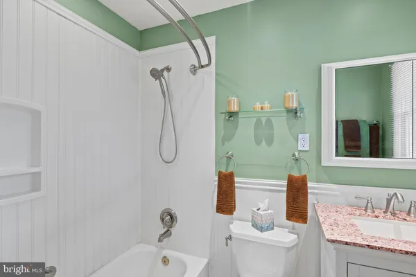 a bathroom with a granite countertop sink a toilet and shower