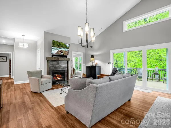 a living room with furniture a fireplace and a chandelier