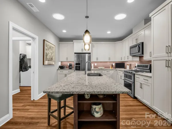 a kitchen with stainless steel appliances granite countertop a stove refrigerator and cabinets