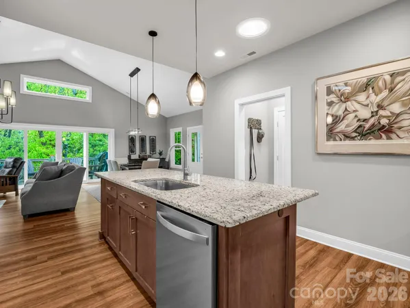 a kitchen with stainless steel appliances granite countertop a kitchen island a stove and a wooden floors