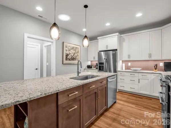 a kitchen with cabinets stainless steel appliances a sink and a refrigerator