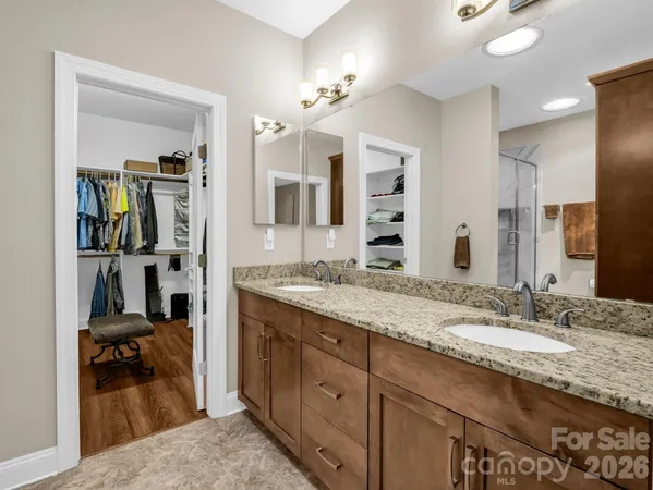 a en suite bathroom with a granite countertop sink and a mirror