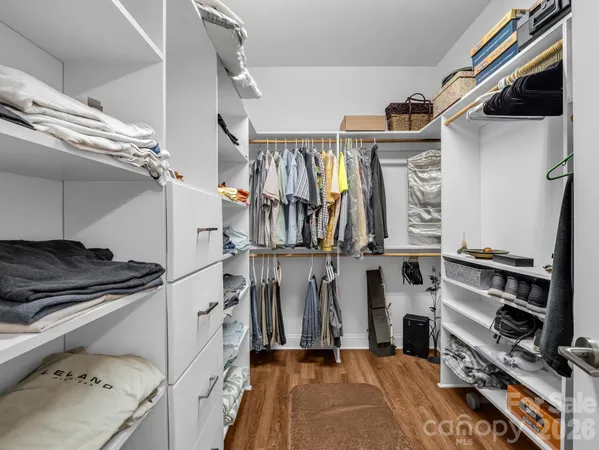 a view of walk in closet with clothes and shoes