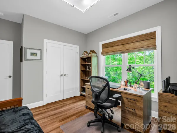 a view of a workspace with furniture and a window