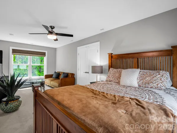 a bedroom with a large bed and potted plant