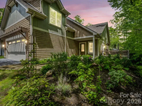 a view of a house with a yard and potted plants