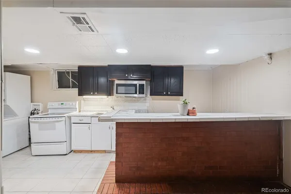 a kitchen with a sink stainless steel appliances and white cabinets