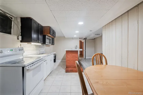 a kitchen with stainless steel appliances granite countertop a sink a stove a microwave a counter top space and cabinets