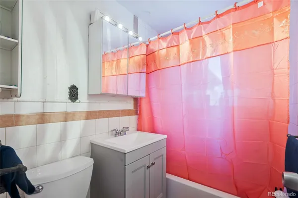 a bathroom with a sink a toilet and shower curtain