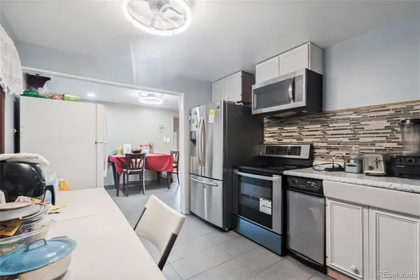 a kitchen with stainless steel appliances kitchen island granite countertop a sink stove and refrigerator
