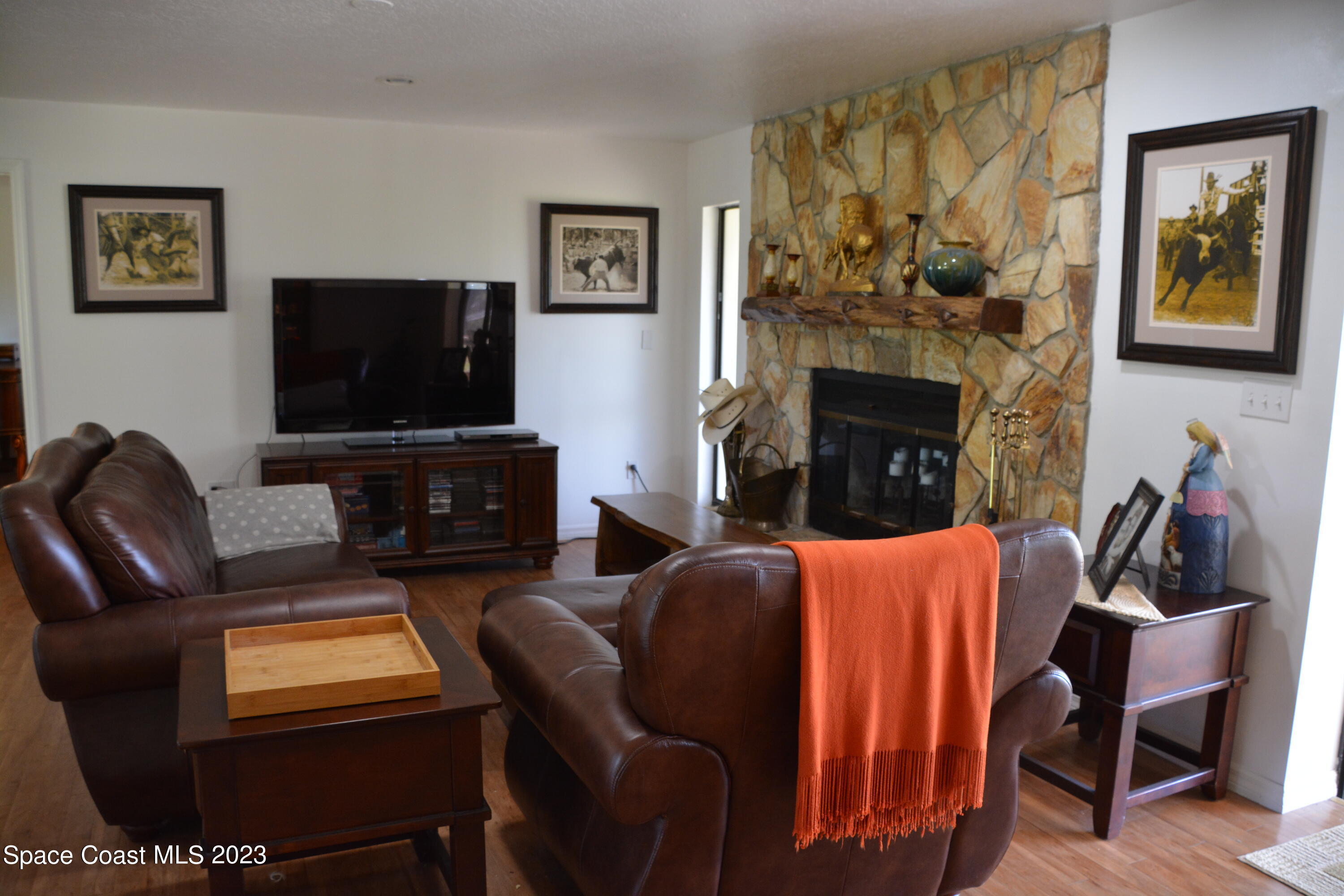 1045 Pine Island Road Merritt Island, FL 32953 - Photo 9 of 42 a living room with furniture a flat screen tv and a fireplace